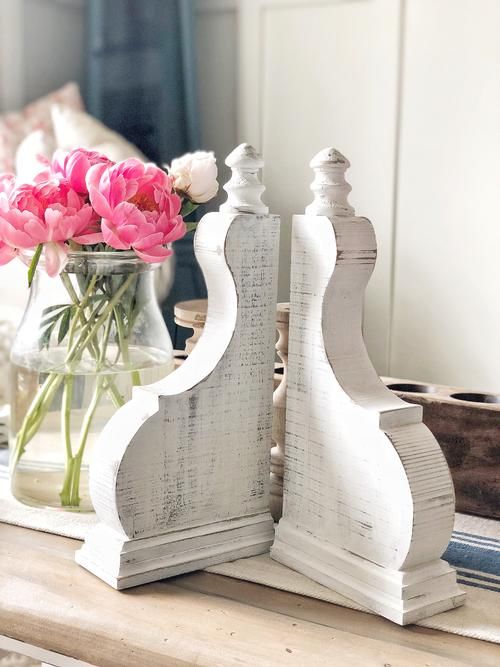 two vases filled with pink flowers sitting on top of a table