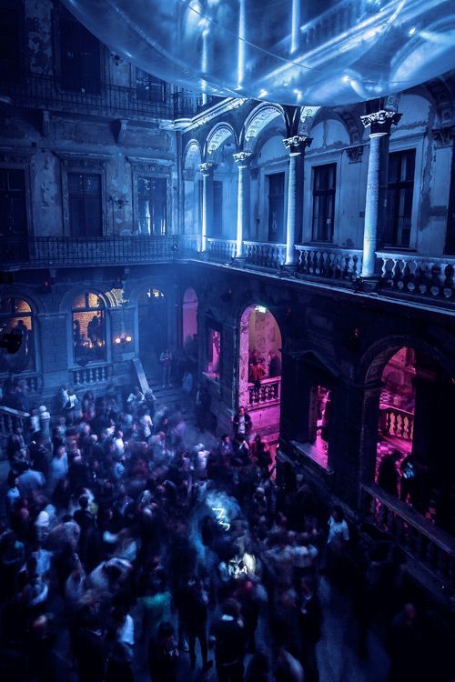 a large group of people standing around in a building