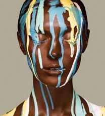 a woman with blue and yellow paint on her face, painted in white and brown