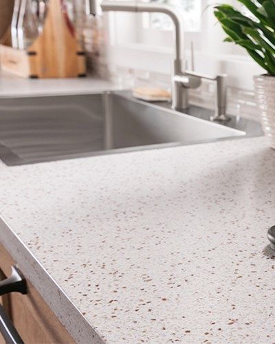 a kitchen counter with a sink and potted plant next to the faucet