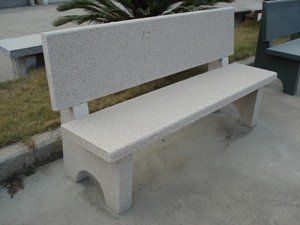 a concrete bench sitting next to a cement planter