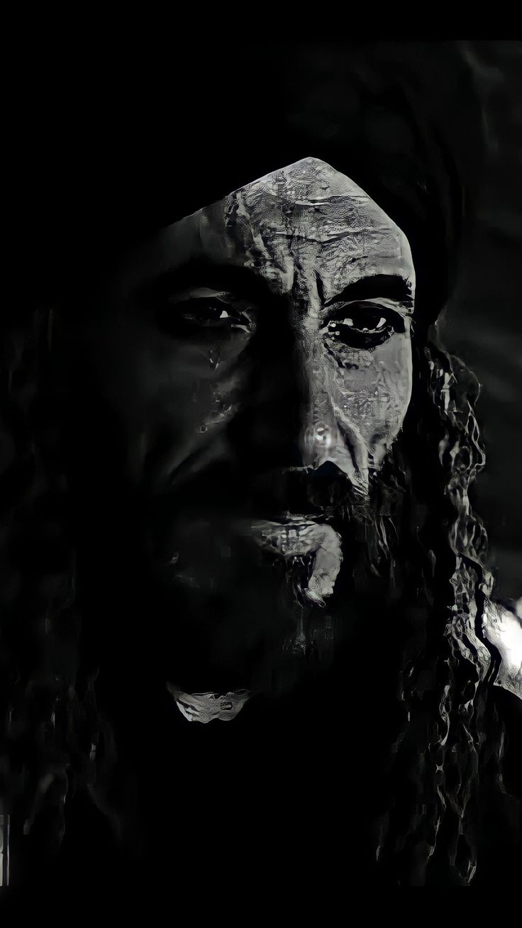 a black and white photo of a man with dreadlocks on his head wearing a hat