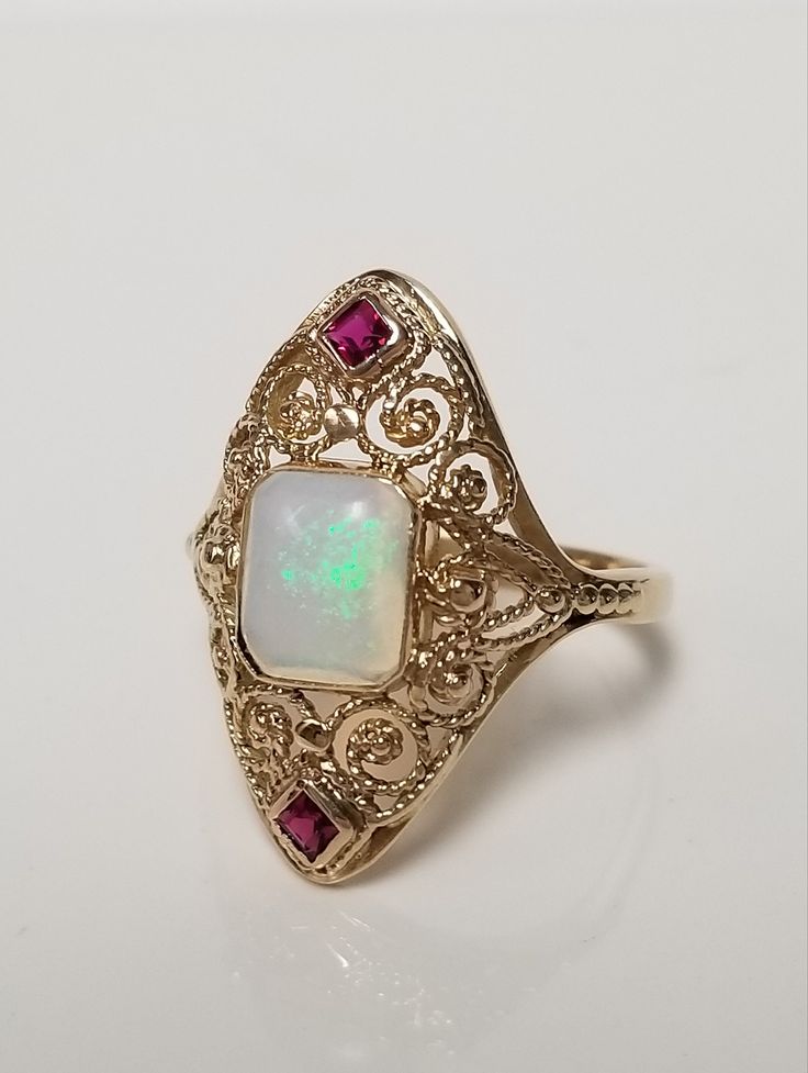 "Thanks for shopping our vintage estate store. We tend to sell well below wholesale and truly hope you enjoy all of our items. Many of the items are one of a kind, so please enjoy scrolling through the pictures and hopefully something will catch your eye. Estate 14k yellow gold natural 1ct opal .10ct ruby Victorian filigree ring. Stunning vintage ring. Ring size: 4.75  Setting: 1/2\" by 3/4\" Band width: 1.5mm Weight: 2.88 grams Beautiful older opal ruby filigree ring. Marked 14k.  As with most estate items there may be some wear on ring. We do not sell new rings, nor do we charge new retail prices." Vintage 14k Stamped Opal Ring For Formal Occasions, Vintage Hallmarked Opal Ring For Anniversary, Vintage Hallmarked Opal Ring For Formal Occasions, Vintage Hallmarked Opal Ring For Formal Events, Vintage Opal Ring Stamped 14k, Vintage 14k Gold Opal Ring, Victorian 14k Gold Opal Ring For Anniversary, Vintage Opal Ring In 14k Gold, Victorian Opal Ring In 14k Gold For Formal Occasions