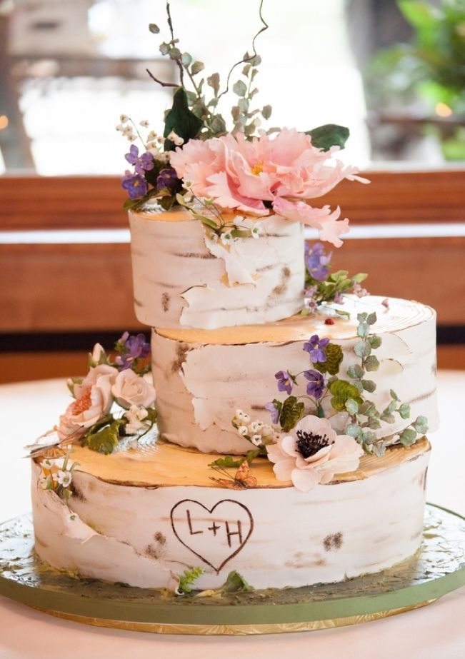 a three tiered wedding cake with flowers on top