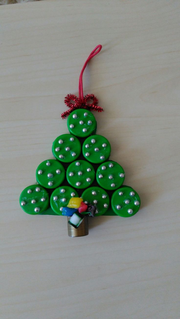 a green christmas tree ornament hanging from a wooden table