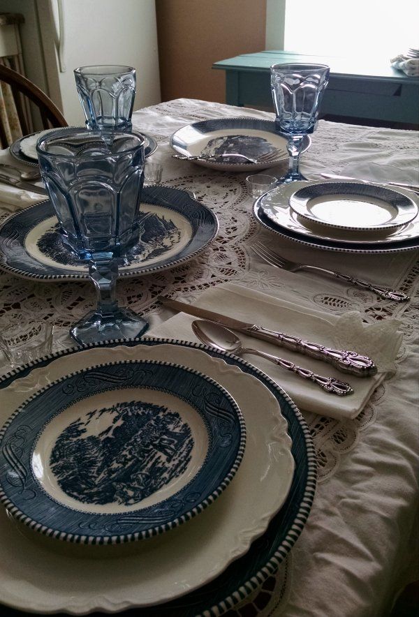 a table set for two with plates and silverware on it, along with place settings