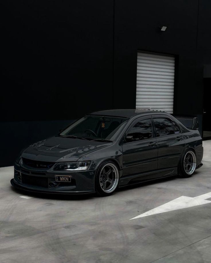 a black car parked in front of a garage