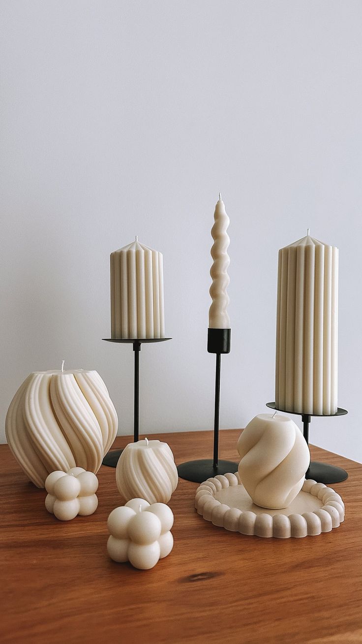 three candles are sitting on a table next to some shells and seashells in front of them