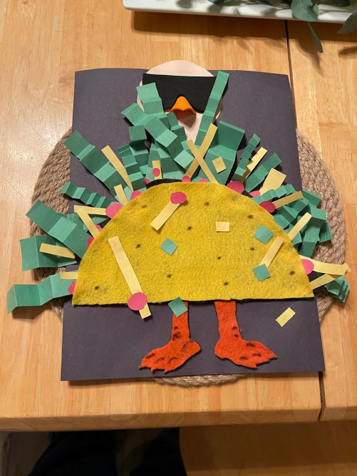 a turkey made out of construction paper sitting on top of a table