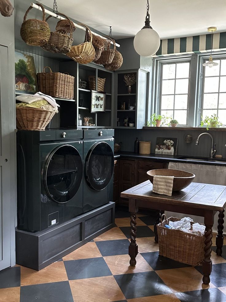 a kitchen with a checkered floor and lots of baskets hanging from the ceiling above it