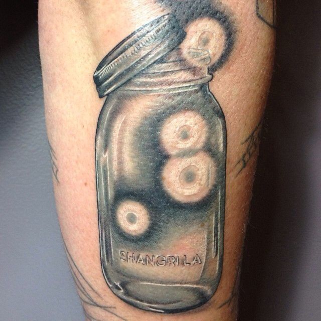 a man's leg with a jar filled with donuts on top of it