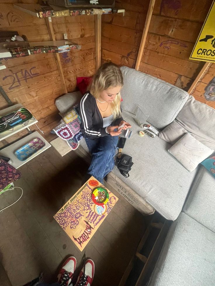 a woman sitting on a couch looking at her cell phone