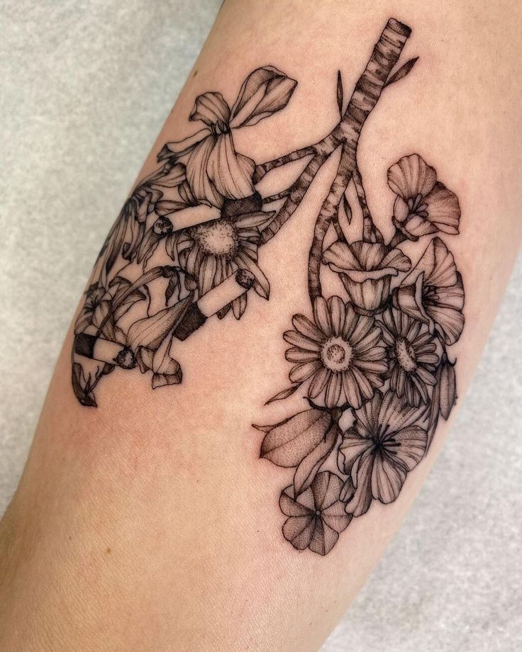 a woman's arm with flowers and a bicycle tattoo on it, which is black and white