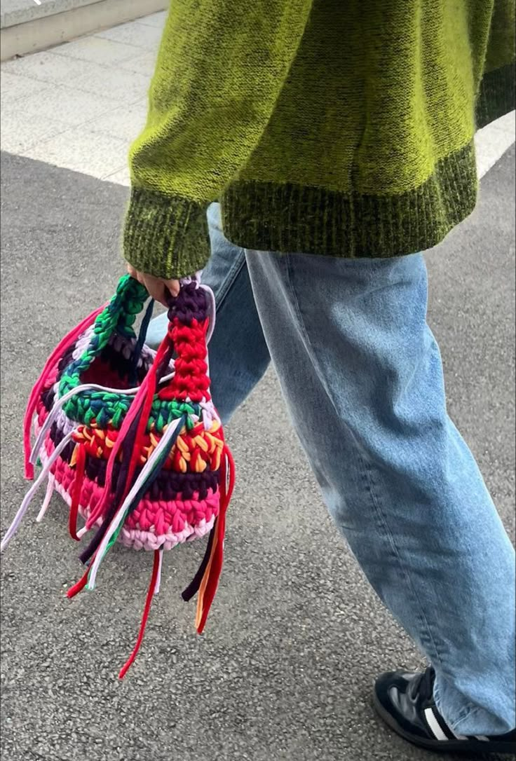 a person is walking down the street with some colorful items in their hand and shoes