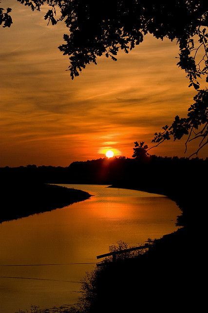 the sun is setting over a body of water