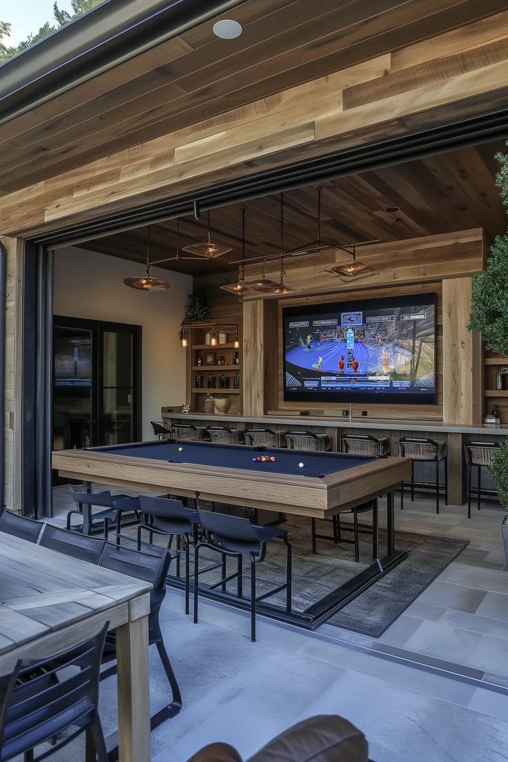 an outdoor dining area with pool tables and television