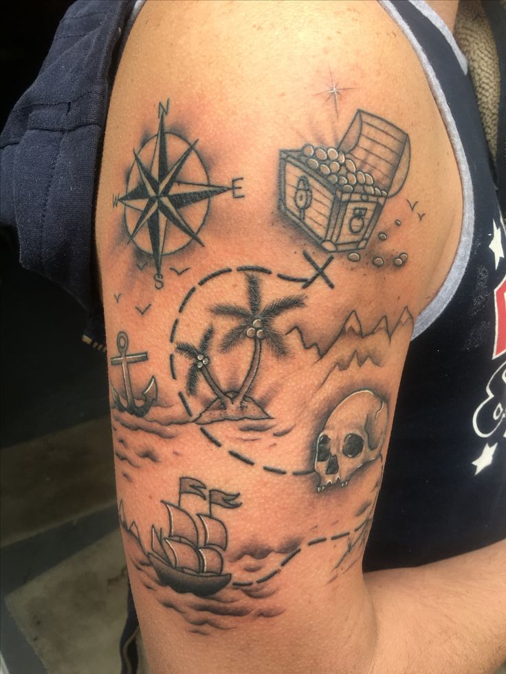 a man with a tattoo on his arm has a pirate ship, compass and skull