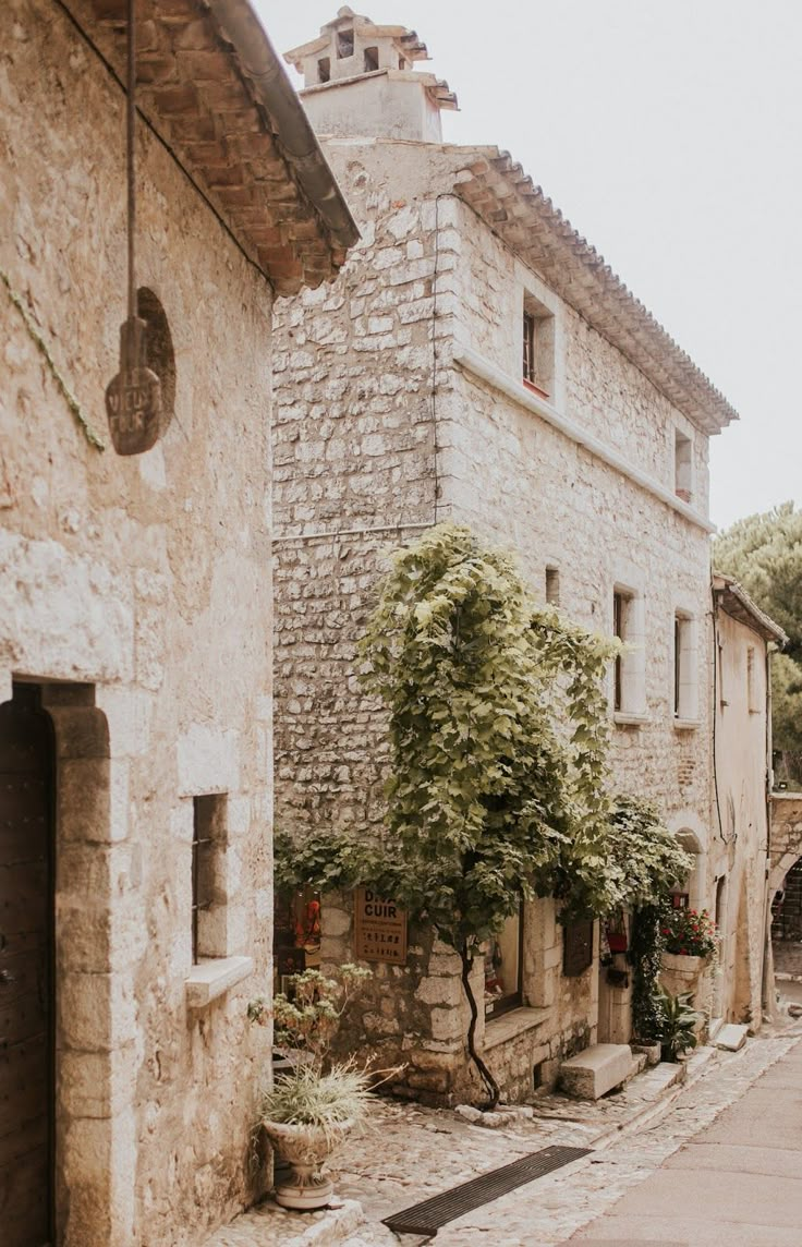 an old stone building sitting next to a tree