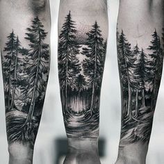 black and white tattoos on the legs of two people with trees in the woods behind them