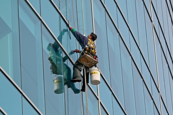 a man working on the side of a tall building