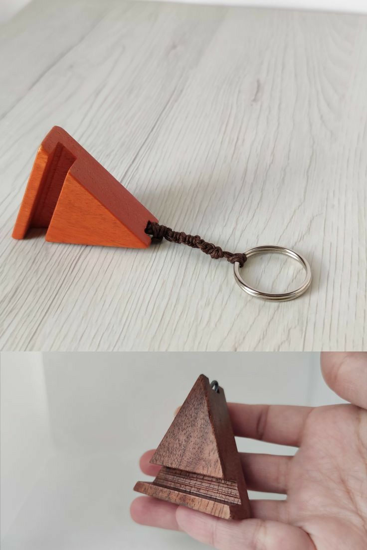 a wooden keychain with a triangle shaped object attached to it's side