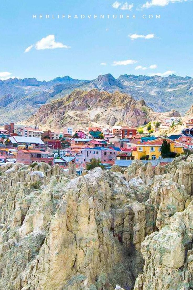 the city is surrounded by mountains and rocky terrain, with colorful houses on top of them