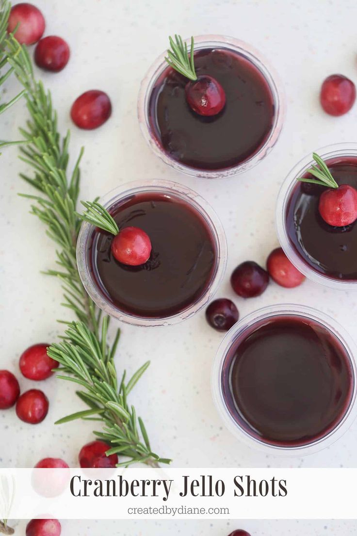 cranberry jello shots with rosemary garnish and cherries on top