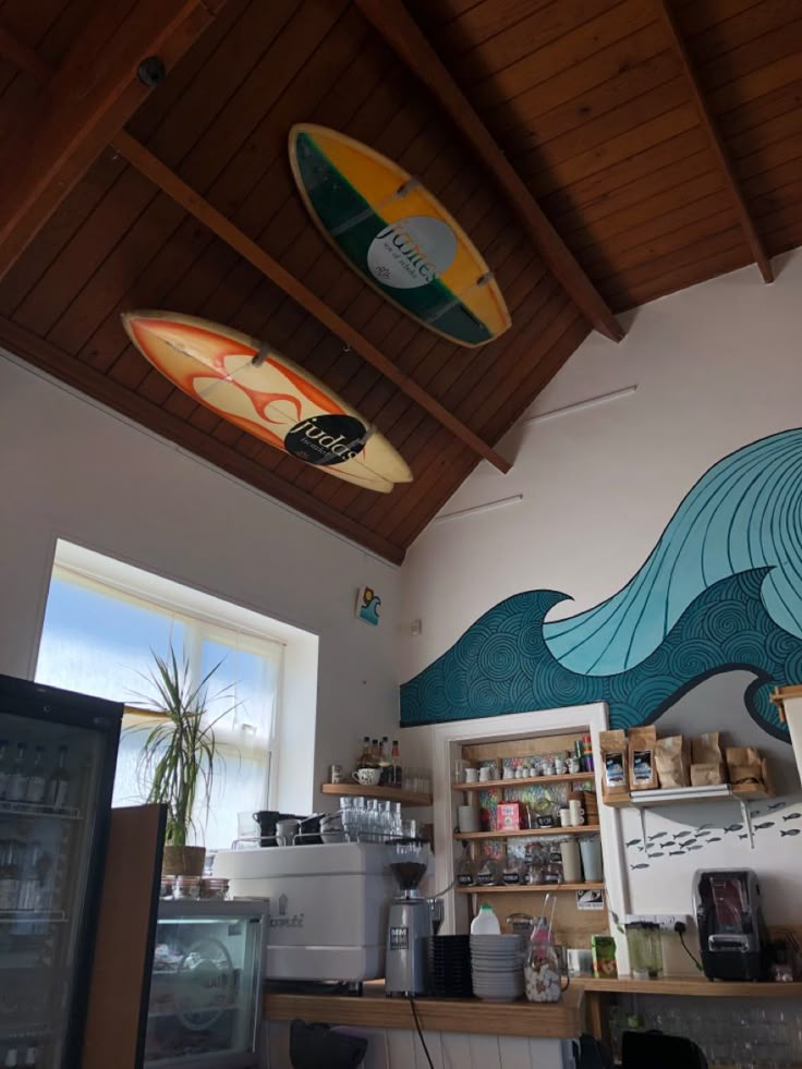 two surfboards hanging from the ceiling above a kitchen counter