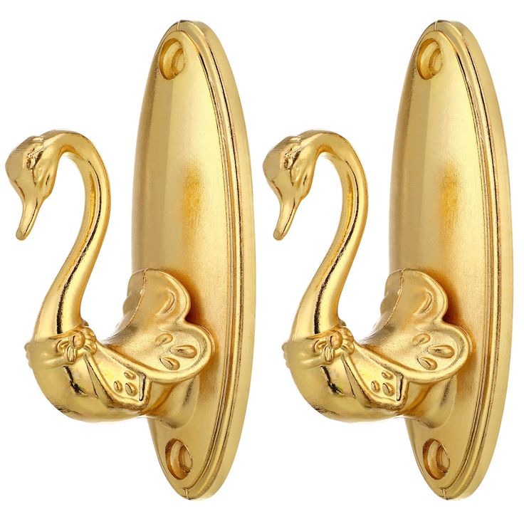 two gold swan shaped hooks on a white background