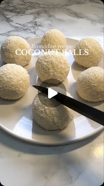 coconut balls on a white plate with a knife