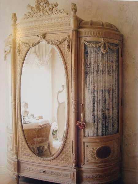 an ornate armoire in the corner of a room with a mirror on it's side