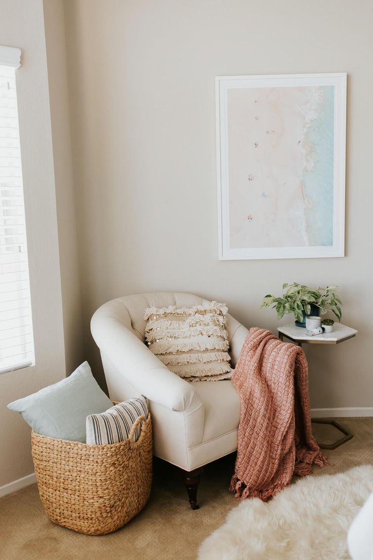 a living room with a white chair and a basket on the floor next to it