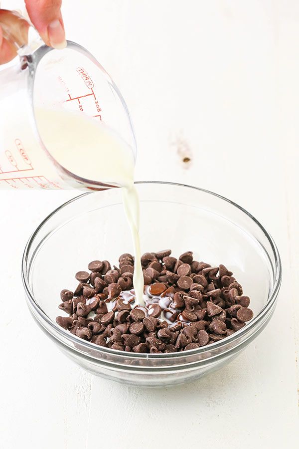 someone pouring milk into a bowl filled with chocolate chips