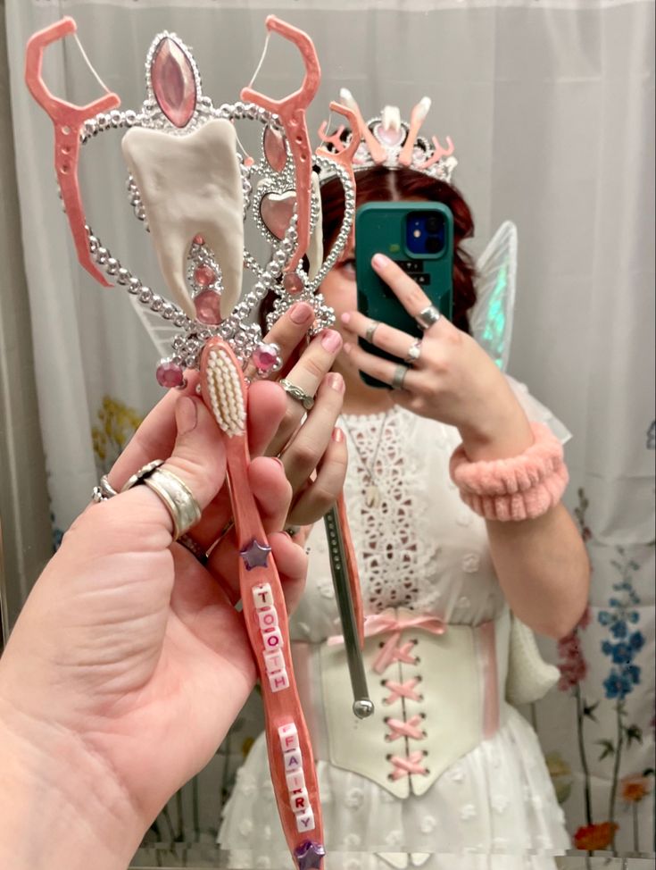 a woman taking a selfie in front of a mirror with toothbrushes and other accessories