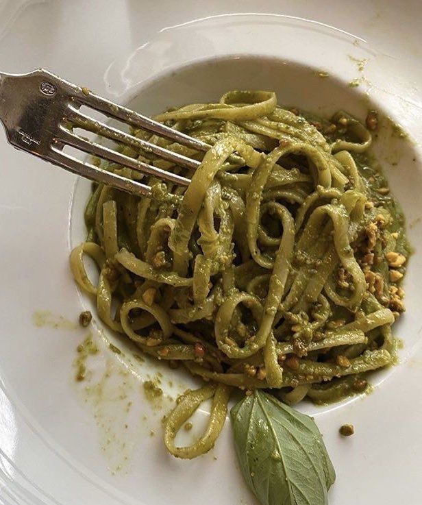 a white plate topped with pasta and pesto