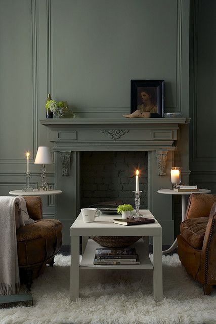 a living room filled with furniture and a fire place in the middle of the room