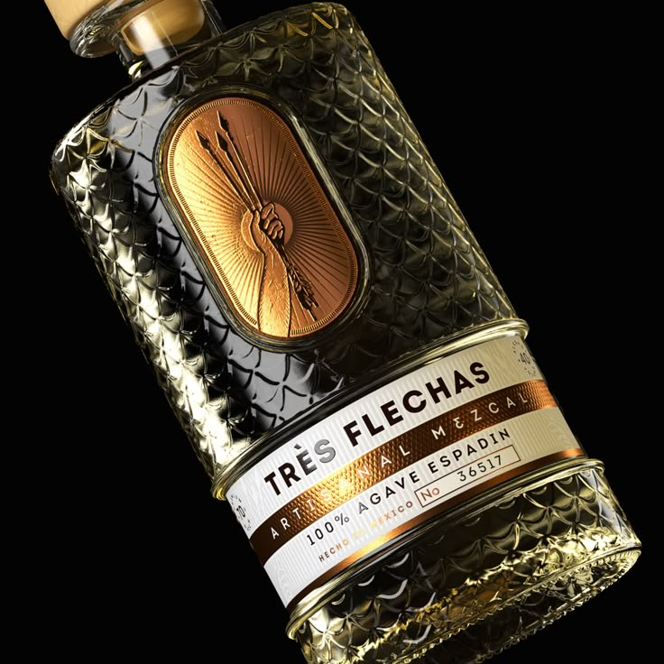 a close up of a bottle of liquor on a black background with gold foiling