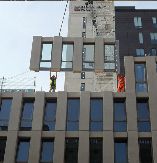 two men working on the side of a tall building