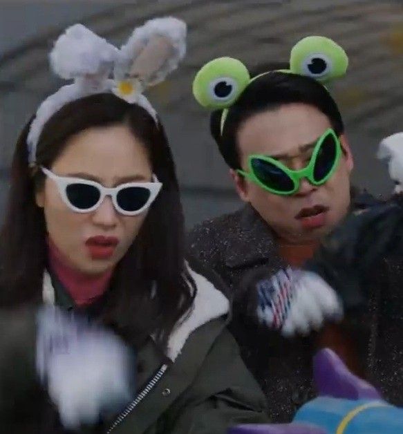 two people wearing green sunglasses and monster ears