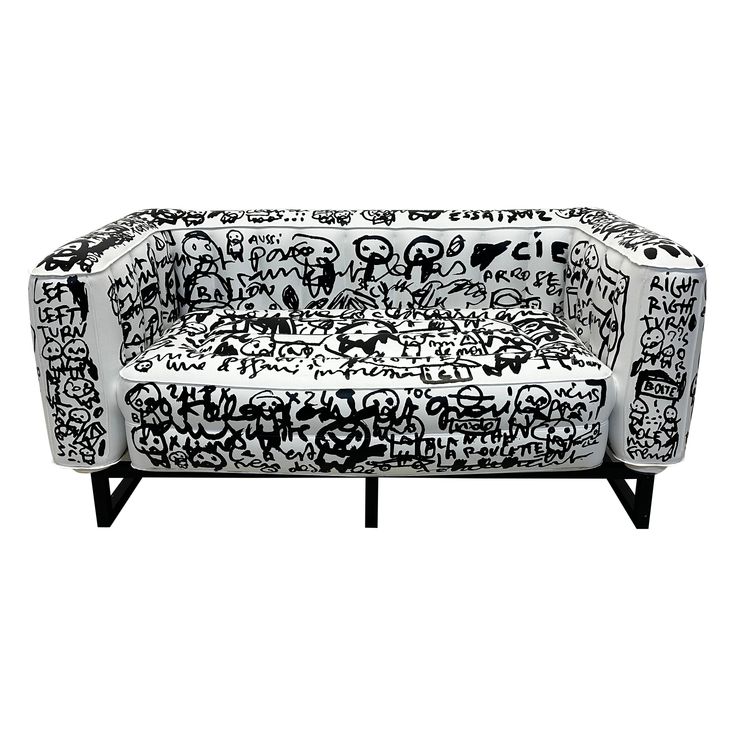 a black and white couch with graffiti on it