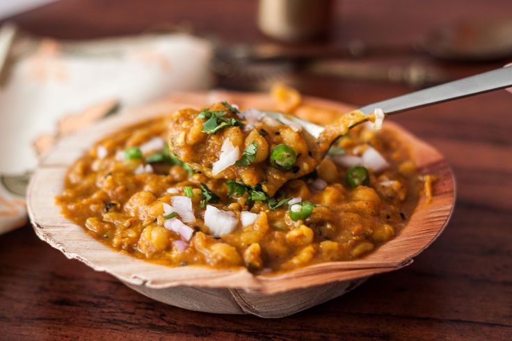 a wooden bowl filled with food on top of a table