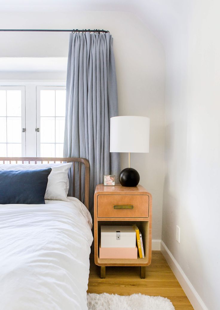 a bedroom with a bed, nightstand and window