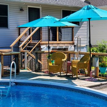 an above ground pool with chairs and umbrellas