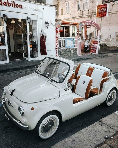 an old white car is parked on the street