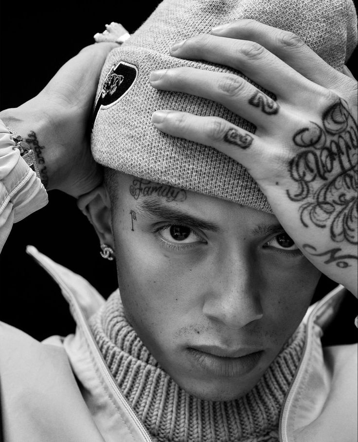 a young man with tattoos covering his face