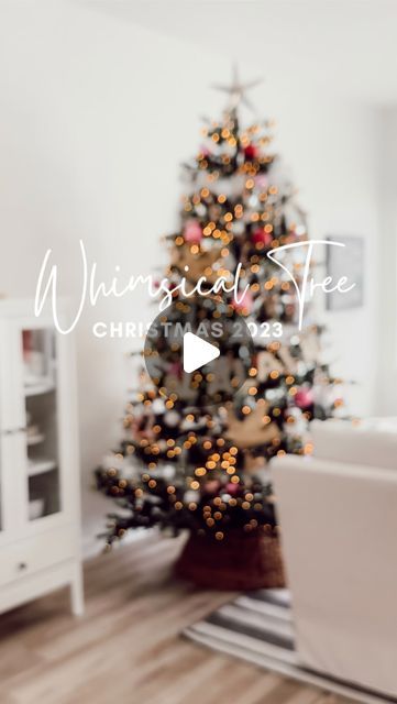 a living room with a christmas tree in the corner and a laptop on the floor