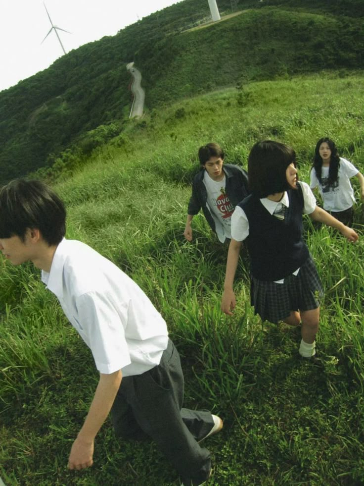 four young people are playing in the grass