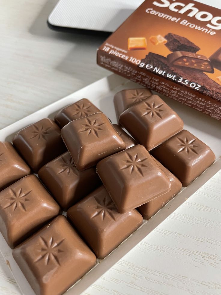 a box of chocolates sitting on top of a table next to a package of chocolate