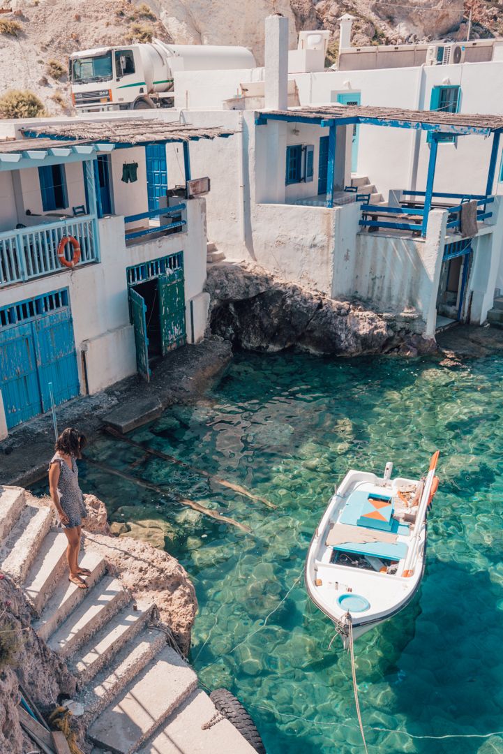 there is a boat that is in the water near some buildings and people on it