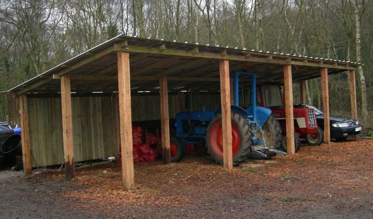 two tractors parked in front of a shed